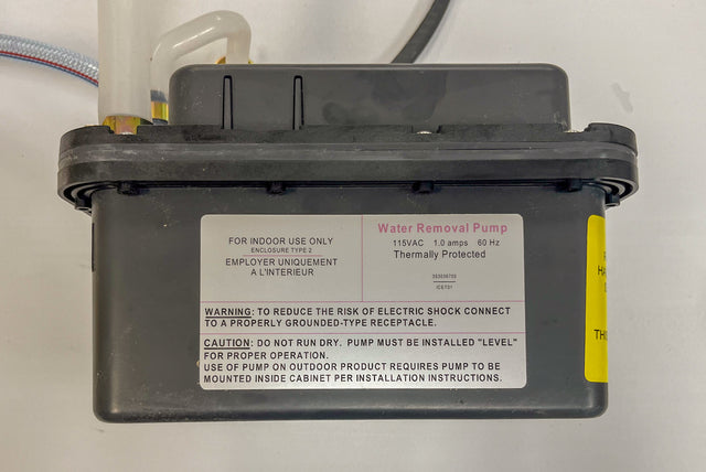 A black plastic Drain Pump labeled IU-0090-AN by Icetro America for indoor use, with warnings about electric shock and proper grounding. The label states: “115VAC, 1.0 amps, 60 Hz, thermally protected.” A white tube and electrical cords are connected.
