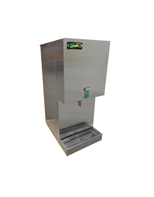 A commercial self-contained ice maker stands on a white background. It has a rectangular body with a chute for dispensing ice and a metal grate tray below to catch overflow. A small blue sign labeled “PUSH FOR ICE” is visible near the chute.