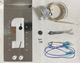 Various refrigerator thermostat replacement parts—including an FS9100 Bin Stat Kit, metal mounting plate, thermostat with probe, plastic bracket, screws, zip ties, and blue electrical wires—are displayed on a white textured surface.