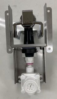 A metal wall-mounted bracket holds an Icetro America chrome and black dispenser above a white plastic valve assembly with a pink ring, set against a plain surface. The components are aligned vertically and securely attached to the bracket.