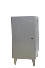 A metallic, rectangular cabinet stands on four short legs. The brushed stainless steel door has a small round lock. The background is white, highlighting the simple, industrial design with subtle vent holes on the right side.