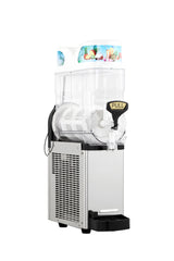 A commercial Icetro America slush machine with a transparent container, white base, black and silver body, and a “PULL” lever. The top displays a colorful fruit graphic. This frozen beverage dispenser sits on a plain white background.