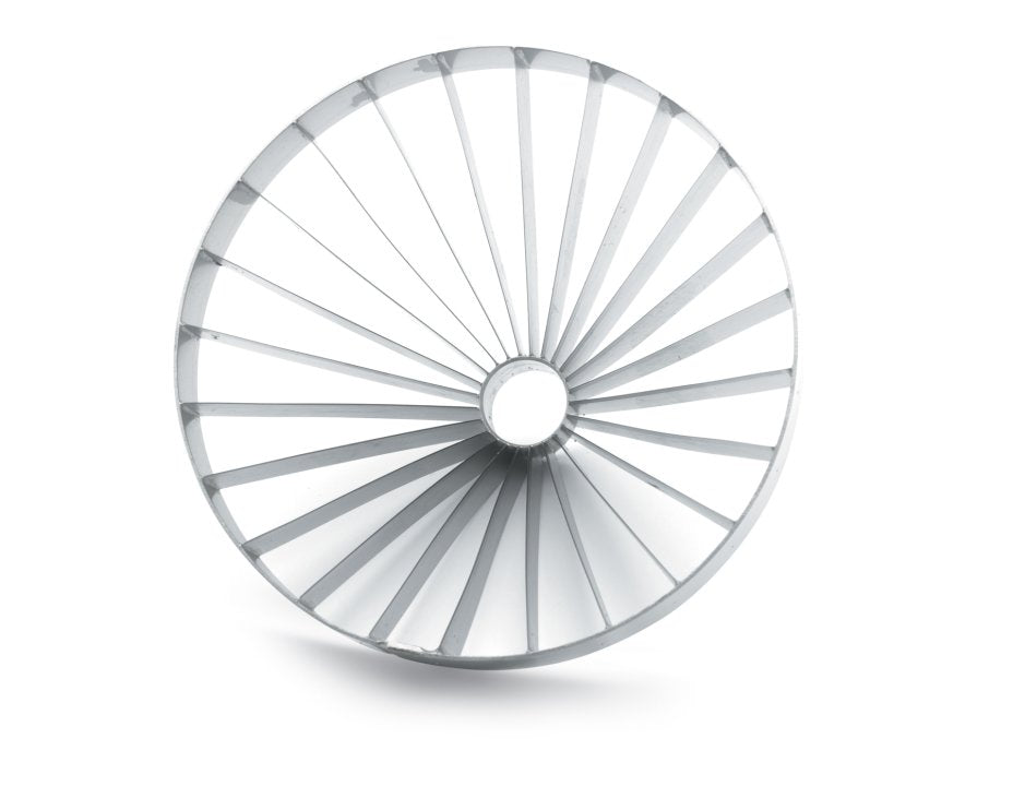 A circular metallic object, resembling a Vollrath blade assembly, features evenly spaced, thin radial spokes extending from a small central hole to the outer rim, creating a wheel-like pattern. The plain white background includes a subtle shadow beneath the object.