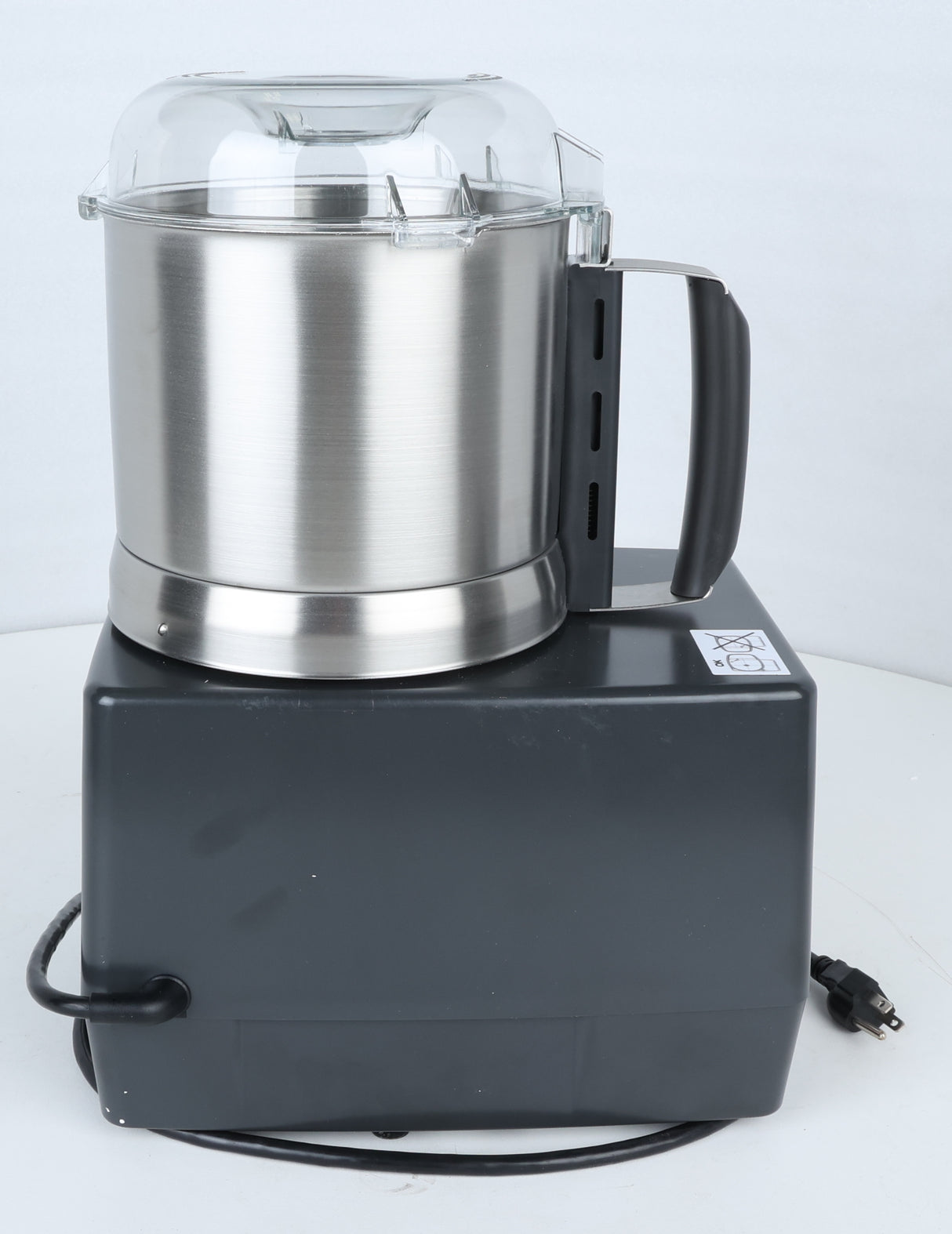 A stainless steel commercial food processor, the Robot Coupe R301U.D, with a black plastic base, clear plastic lid, and black handle sits on a white surface. Perfect for efficient vegetable prep tasks, an electric cord with a plug is wrapped around the base. A caution sticker is visible on the top right corner of the base.
