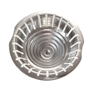 A top-down view of a round, stainless steel sink strainer with evenly spaced vertical slots around the edge and a slightly raised, domed center. The shiny surface and two small side tabs allow for easy removal or use as a replacement strainer cone.