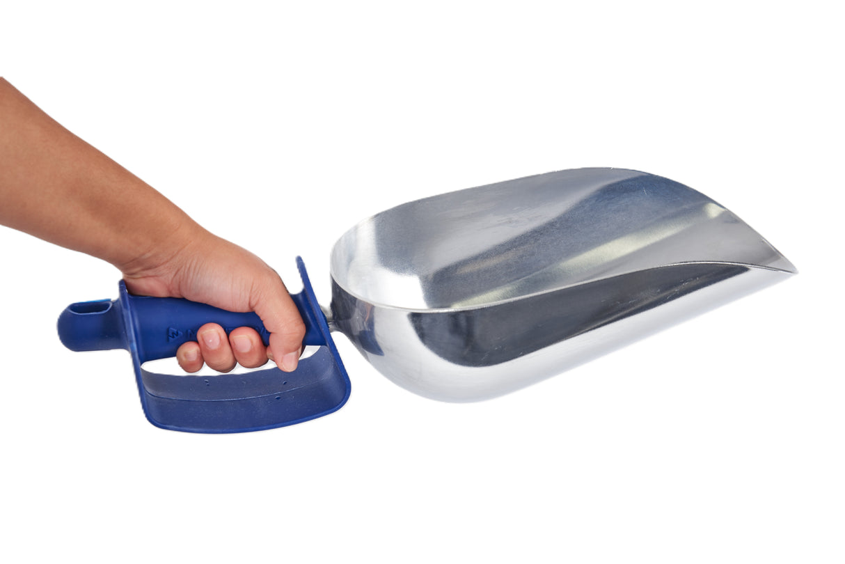 A person’s hand holds a large, shiny Manitowoc cast aluminum ice scoop with a wide, deep bowl and a blue ergonomic handle, isolated on a white background. The scoop appears suitable for handling bulk materials like grain, pet food, or ice.