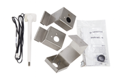 A set of metal mounting brackets, a white electronic probe with black cable, a black knob, screws, and an instruction manual labeled “Manitowoc Indigo NXT Series Dispenser Thermostat Kit” are arranged on a white surface.
