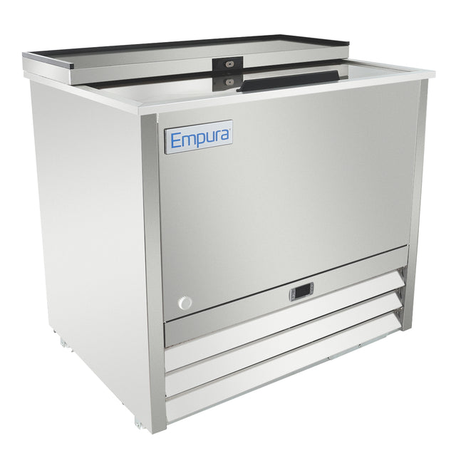 A stainless steel Empura commercial bottle cooler with a sliding, recessed lid, front-facing vent panel, and blue Empura logo on the top left front. This commercial freezer features a modern, rectangular design and is set against a plain white background.