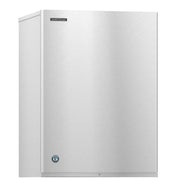 A sleek, industrial Cube-Style Hoshizaki ice maker with a plain, smooth stainless steel front panel, a small logo at the top left, and a round blue emblem near the bottom left. No visible handles or buttons maintain its modern look.