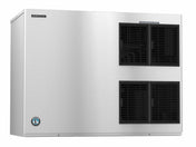 A large, rectangular, stackable industrial ice maker with a brushed metal finish features three black vented panels on the right and a small blue circular logo near the bottom left. A manufacturer's label sits at the top left on the front panel.