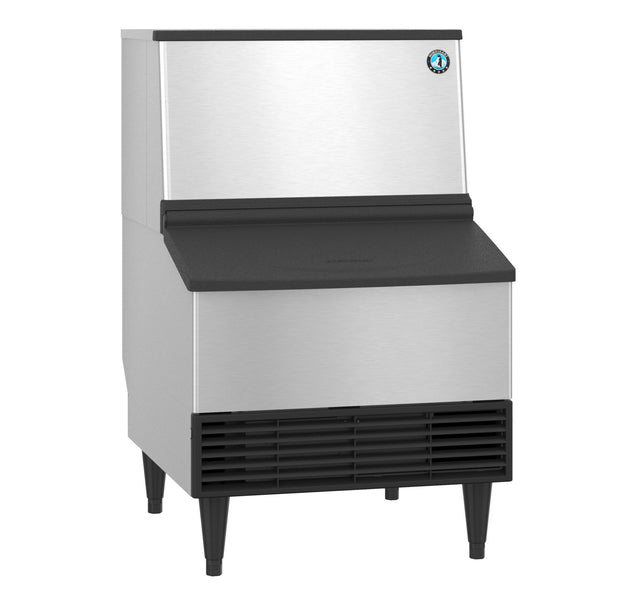 A Hoshizaki Cube-Style Ice Maker with a stainless steel exterior, black top edge, and black vent at the bottom. It stands on four black legs and features a front access bin, plus a round blue and white logo on the upper right corner.