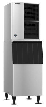 A tall, stainless steel Hoshizaki ice maker with black vents on the upper portion and a large black ice bin below, standing on four sturdy legs. The machine produces Crescent Cube ice and features a rectangular shape with a logo visible on the upper section.