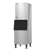 A commercial stainless steel ice maker with a boxy design, black front access panel, and four sturdy legs. The upper compartment produces crescent cube ice, while the lower part serves as the storage bin. The surface is sleek and metallic.