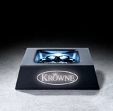 A square black metal glass chiller with stainless steel construction features a central circular rinser and four spokes, branded with a glowing “KROWNE” logo on the front. The illuminated rinser area highlights its sleek, industrial design.
