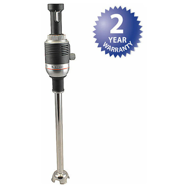 A commercial immersion blender with a black handle and silver blending shaft is shown upright. Next to it, a blue starburst badge displays 2 YEAR WARRANTY in white text. This heavy duty immersion blender stands out against the plain white background.