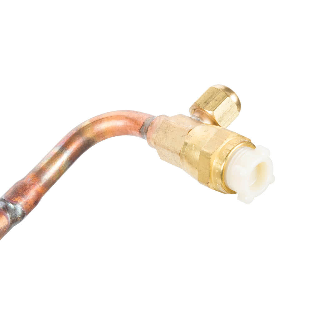 Close-up of a copper pipe from a Manitowoc Remote Tubing Kit with a brass compression fitting attached to the end. The fitting has a white plastic insert and hexagonal nut. The bent pipe shows discoloration against a white background.
