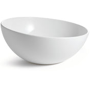 A plain, smooth white melamine bowl from the Sierra Melamine Collection sits on a white surface, photographed at an angle that highlights its round, deep interior and slightly glossy finish. This dishwasher safe bowl casts a soft shadow to the left.