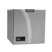 A stainless steel, box-shaped Scotsman cube ice machine with a black Scotsman logo on the front, digital control panel, and a smooth, reflective finish. The panel features several icons and a display screen. This ice maker is set against a plain white background.