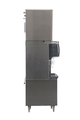 A side view of a large stainless steel commercial ice and water dispenser, featuring a cup under the chute, four long legs, and a drip tray below—compatible with the ICELINQ® mobile app for easy monitoring; background is plain white.
