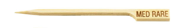 A light bamboo meat marker pick with a pointed tip and a flat, rectangular handle engraved with MED RARE in capital letters, indicating medium rare doneness for foods like steak.