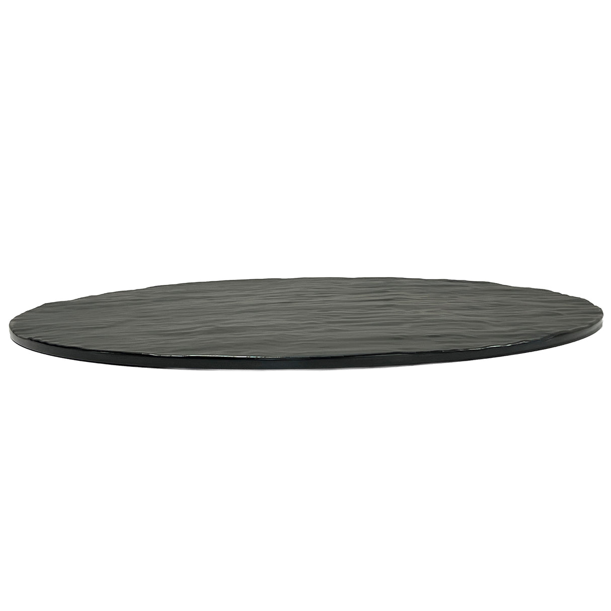 A round, flat black Frostone Collection Display Tray features a slightly uneven, textured surface and rough edges. This break resistant tray is thin and strikingly photographed from a low angle against a white background.