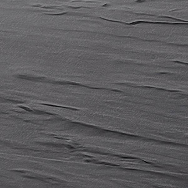 A close-up view of a gray melamine surface with visible, slightly uneven, wavy lines and subtle wrinkles, resembling crumpled fabric or a textured plastic sheet—perfect for a display tray that’s both stylish and dishwasher safe. The lighting highlights the contours.