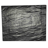 A rectangular, slightly uneven black slate display tray with subtle grooves and wavy texture, resembling natural stone. Its rough edges and matte finish give it an organic, rustic appearance against a white background. Break resistant melamine construction.