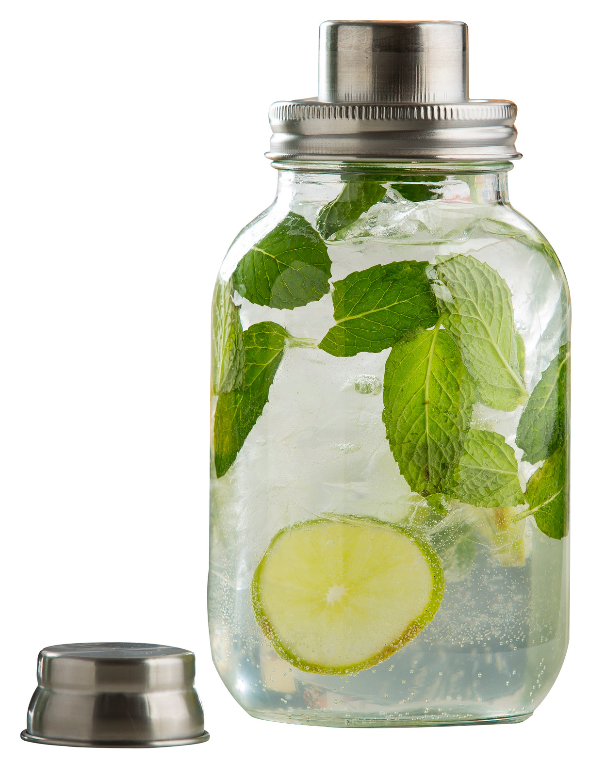 A 14 oz Mason Jar Cocktail Shaker filled with clear liquid, ice cubes, fresh mint leaves, and a lime slice. The stainless steel lid is screwed on, while the matching cap rests beside the jar against a plain white background.
