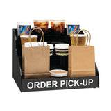 A black order pick-up display stand holds brown paper bags, cups with lids, cold drinks, coffee cups, straws, and napkins—efficiently set up on the counter for customers to collect their to-go orders.