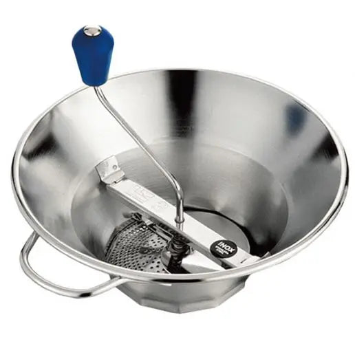 A Matfer Bourgeat X3 Food Mill with a wide, shallow stainless steel bowl, a perforated disc at the bottom, a crank handle with a blue handle, and a side handle for stability. The food mill is clean and empty against a white background.