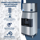A commercial vending ice dispenser stands on the right, with a metal finish and a front touchless lever for dispensing ice. To the left, text highlights 9-1/2” clearance, DuraTech corrosion-resistant finish, and built-in agitator. Ice forms the background.