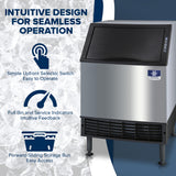 A Manitowoc ice machine with a black front panel and stainless steel body is shown. Overlaid text highlights features: intuitive design, simple selector switch, easy feedback indicators, and a forward-sliding storage bin for access.