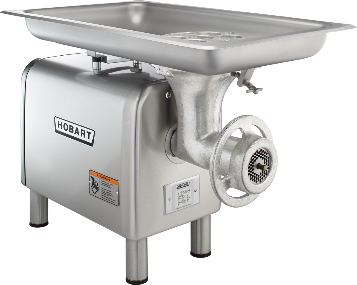 A stainless steel Hobart bench type Meat Chopper with a large rectangular tray on top, a grinding mechanism at the front, and sturdy legs. Featuring a powerful 1-1/2 HP motor, it’s built for heavy-duty food processing with clear branding and warning labels.