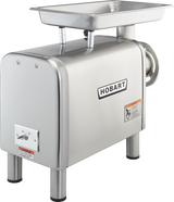 A commercial Hobart bench type Meat Chopper made of stainless steel with a rectangular tray on top, grinding tube on the right, 1-1/2 HP motor, four sturdy legs, control switches on the front, warning labels, and Hobart logo prominently displayed.
