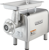 A stainless steel Hobart Meat Chopper with a powerful 1-1/2 HP motor features a rectangular feed tray on top, grinding mechanism and disk at the front, and four cylindrical legs. The bench type grinder displays the Hobart logo and several information labels.