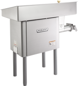A large Hobart Meat Grinder with a powerful 5 HP motor stands on four gray legs. This stainless steel machine features a rectangular hopper, side-mounted grinding mechanism, and clearly marked control labels on its front and side panels.