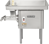 A Hobart Meat Grinder with a powerful 5 HP motor, made of stainless steel, features a large rectangular tray, a left-side chute for ground meat, front control buttons, sturdy legs for support, and a plastic tamper resting in the upper tray.