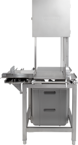 A large industrial meat saw, the Hobart 6614-1, features stainless steel construction, a rectangular cutting table, adjustable guides, and a plastic container below for collection. The sturdy machine includes voltage specification details on its upper housing.
