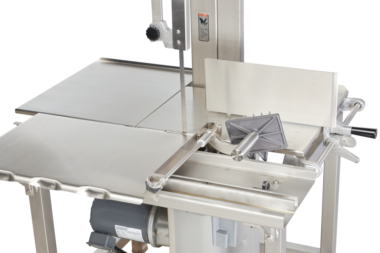 A close-up of a Hobart 6801-18IP commercial meat band saw, featuring a vertical metal blade, integrated pusher, stainless steel work surfaces, safety push handle, and motor underneath—designed for precise meat cutting and optimal voltage specification.