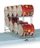 A corrosion-resistant can rack holds eight large tomato cans in two rows on blue Metro shelves. The rack allows cans to roll forward for easy access, and the cans are labeled “Hunt’s” with images of tomatoes.