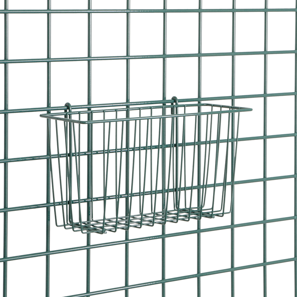 A rectangular epoxy-coated metal wire basket is attached to a grid-style wire wall. The SmartWall Storage Basket is empty, featuring thin, evenly spaced rods; both basket and wall are dark green. The background remains plain and uncluttered.