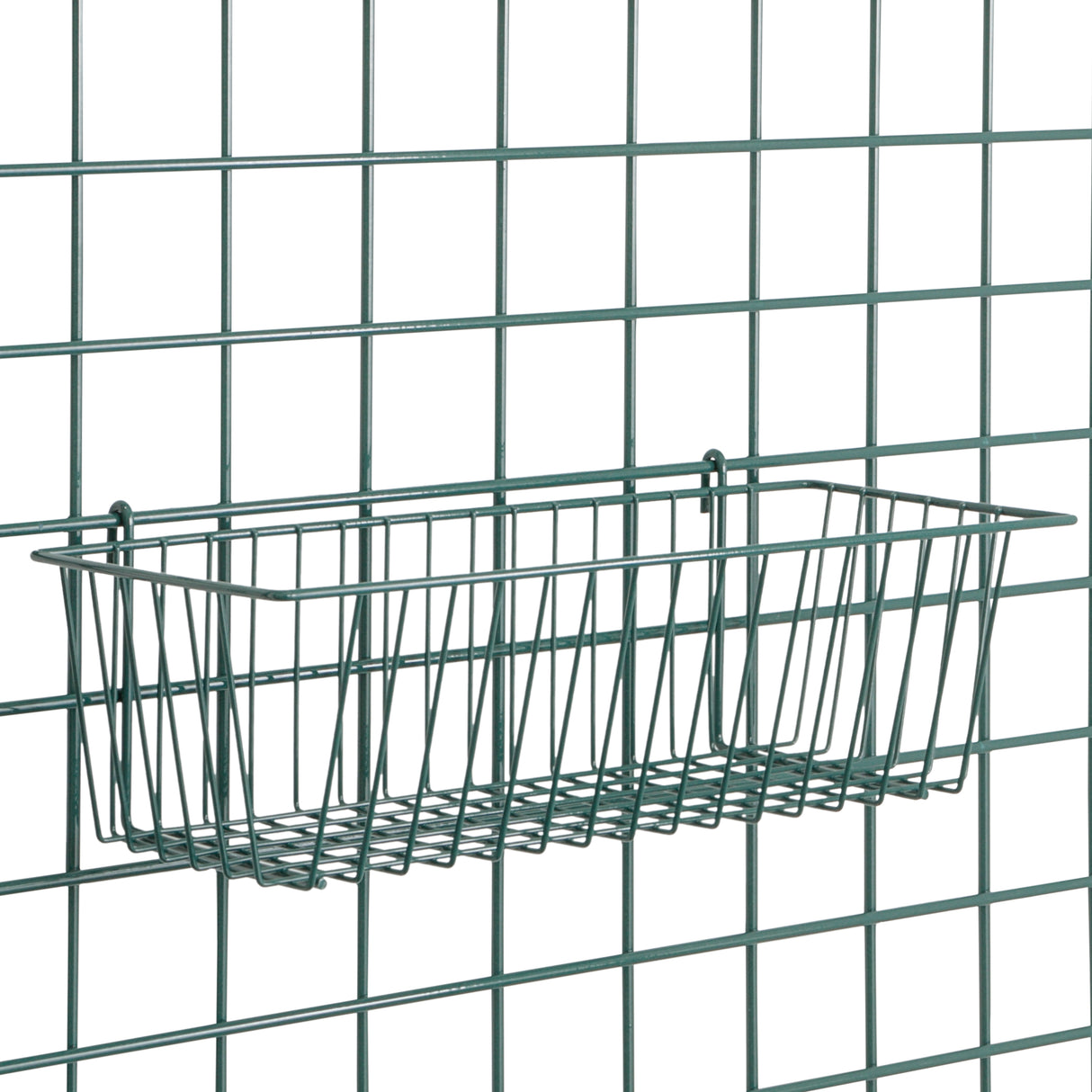 A rectangular SmartWall Storage Basket is attached to a metal grid wall. Made of thin metal rods with a minimalist design, the basket features Metroseal 3 antimicrobial protection for safe and organized storage.