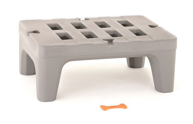 A gray plastic step stool made from corrosion proof polymer, with a slatted grid-like top and sturdy legs, stands on a white background. In front of the stool is a small orange bone-shaped object.