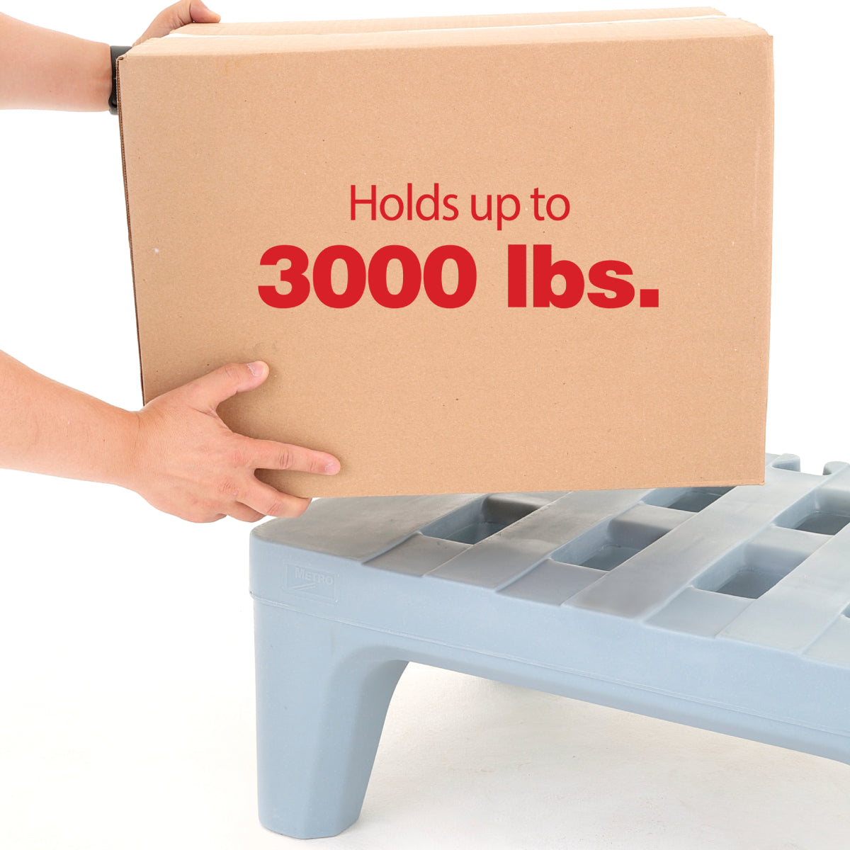 A person places a large cardboard box labeled Holds up to 3000 lbs. onto a Dunnage Rack made of rust proof polymer. Only the person's hands and arms are visible, with a plain white background.
