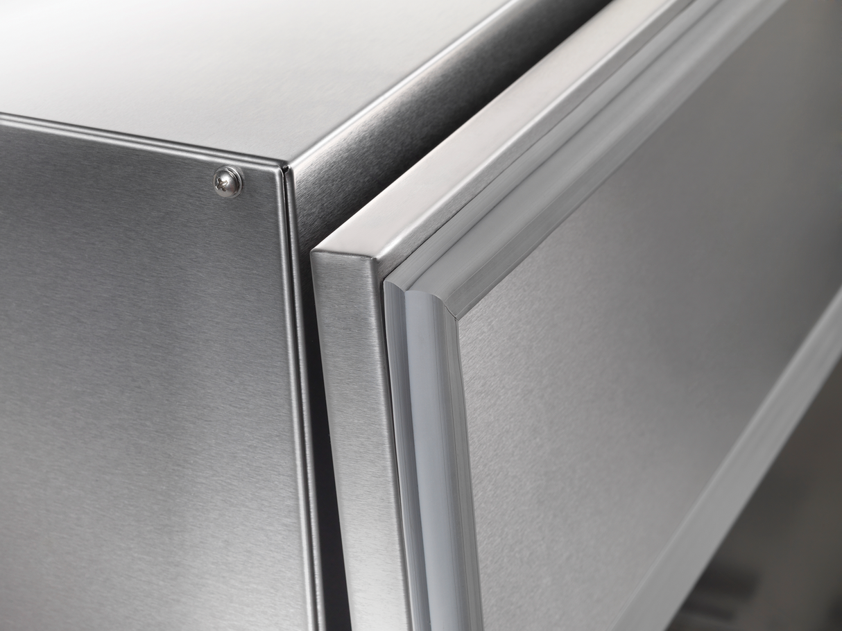 A close up of a silver refrigerator, featuring the sleek design similar to a Traulsen milk cooler.