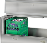 A green crate sits in a drawer beneath a Traulsen milk cooler.
