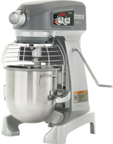 A large 12 quart planetary mixer with a stainless steel mixing bowl, safety guard, and control panel on top. The metallic gray bench mixer has a HOBART label, various dials and levers, plus an orange warning sticker.