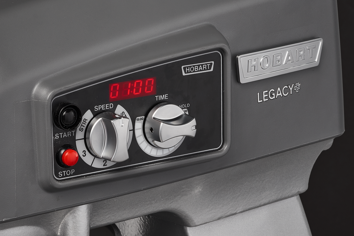Close-up of a control panel on a Hobart Legacy 20 quart planetary mixer. The panel includes a digital display showing 01:00, speed and time knobs, START and STOP buttons, and “HOBART” and “LEGACY” labels in raised lettering.