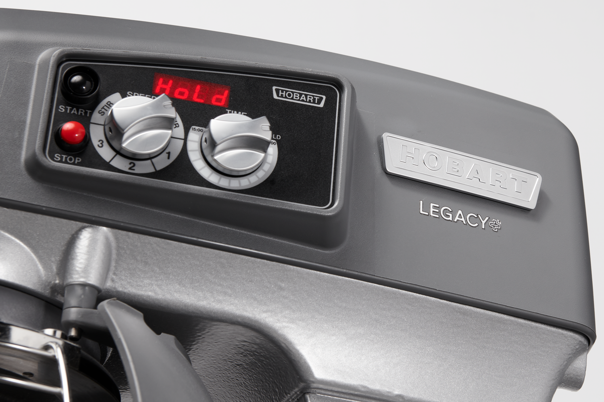 Close-up of a gray Hobart Legacy 20 quart planetary mixer control panel, showing two dials labeled 1, 2, 3, and stir; a red LED display reads “HoLd.” The machine features prominent Hobart branding on a metallic label.