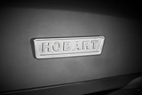 A close-up of a metallic rectangular nameplate with “HOBART” embossed in capital letters, attached to the body of a 20 quart planetary mixer. The lighting casts subtle shadows, highlighting the raised text and textured background.